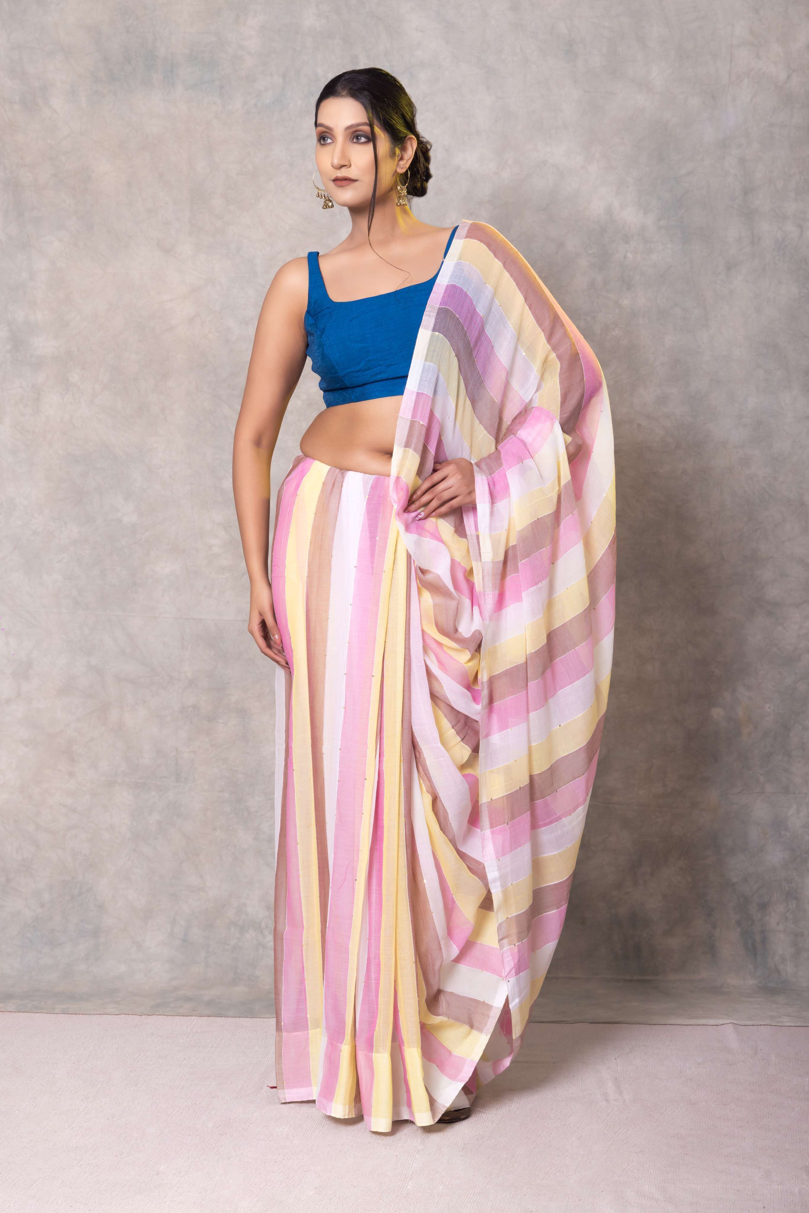 Woman wearing a colorful saree with a blue blouse against a gray background