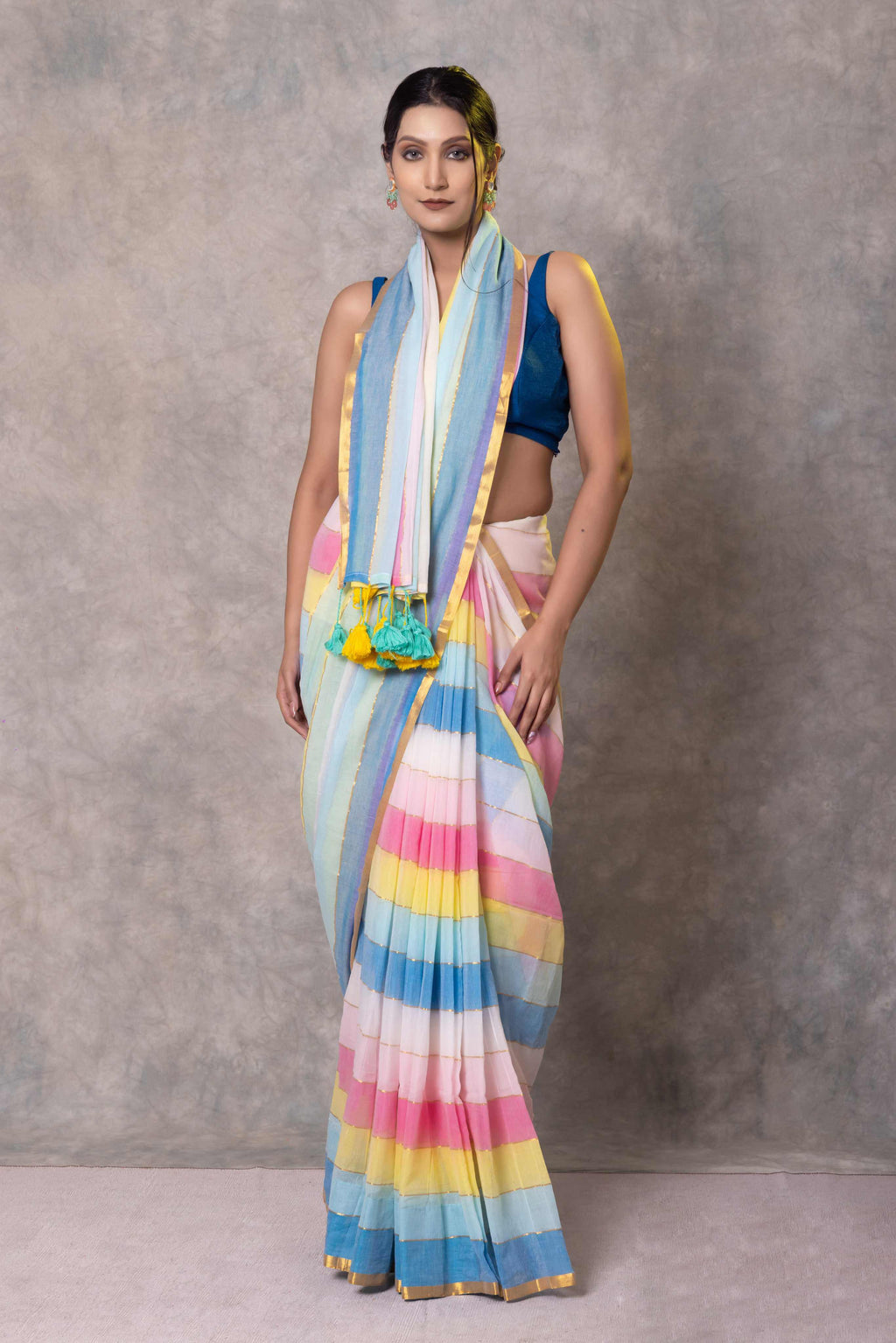 Woman wearing a colorful striped saree with a plain background