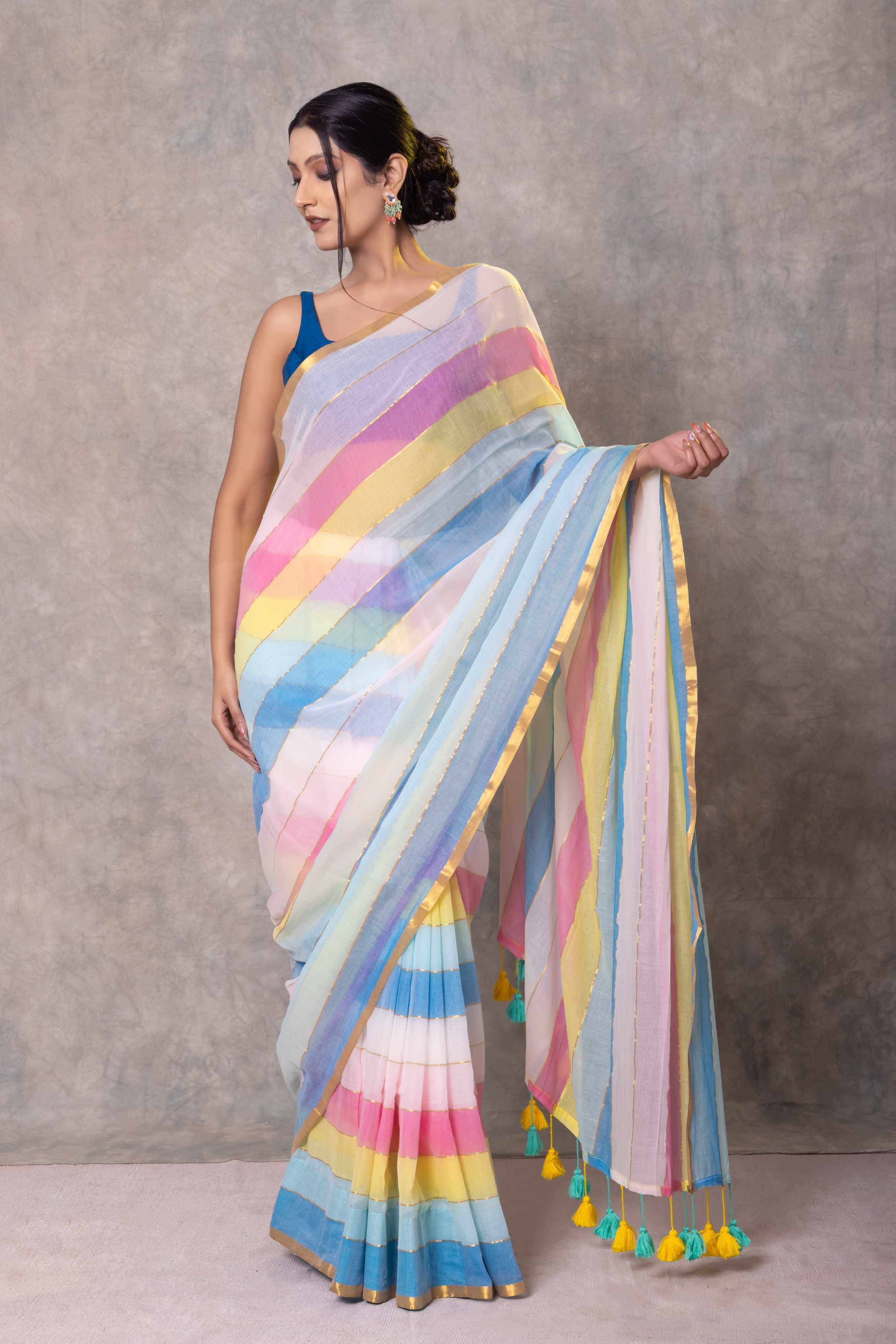 Woman wearing a colorful striped saree against a neutral background