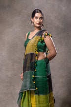 Woman wearing a green and yellow traditional outfit against a gray background