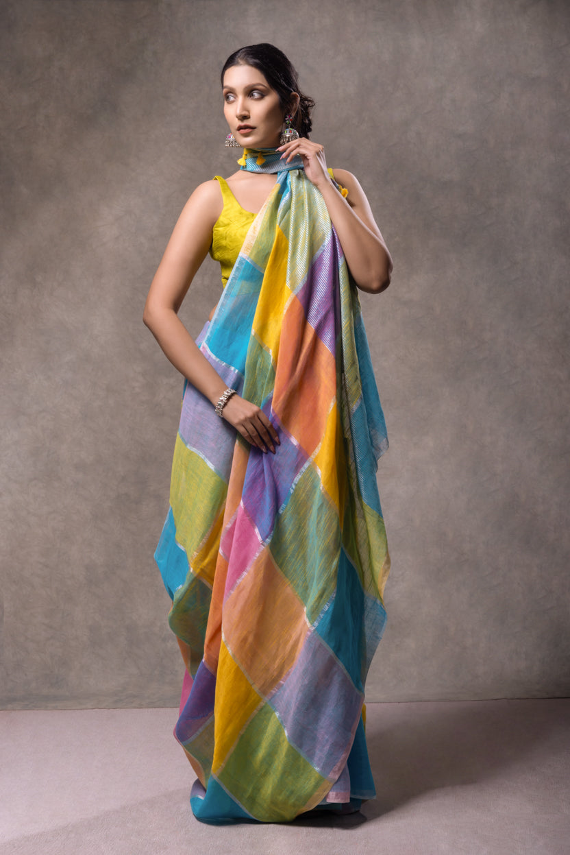 Woman holding a colorful saree against a gray background