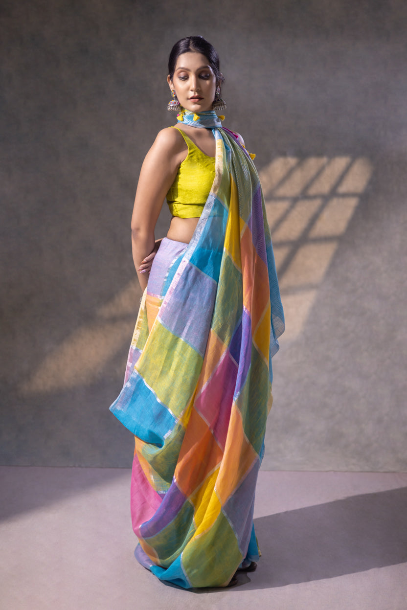 Woman wearing a colorful striped saree with a yellow blouse against a neutral background