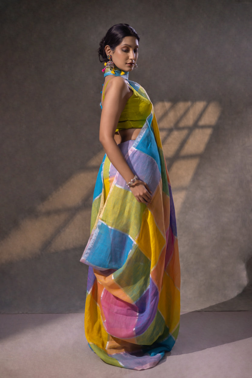 Woman wearing a colorful saree with a yellow blouse against a neutral background