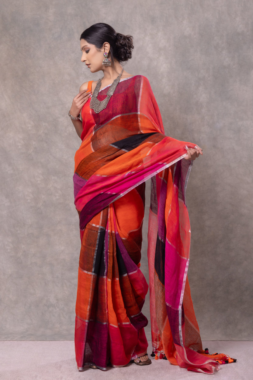 Woman wearing a vibrant saree with a gradient of colors against a neutral background