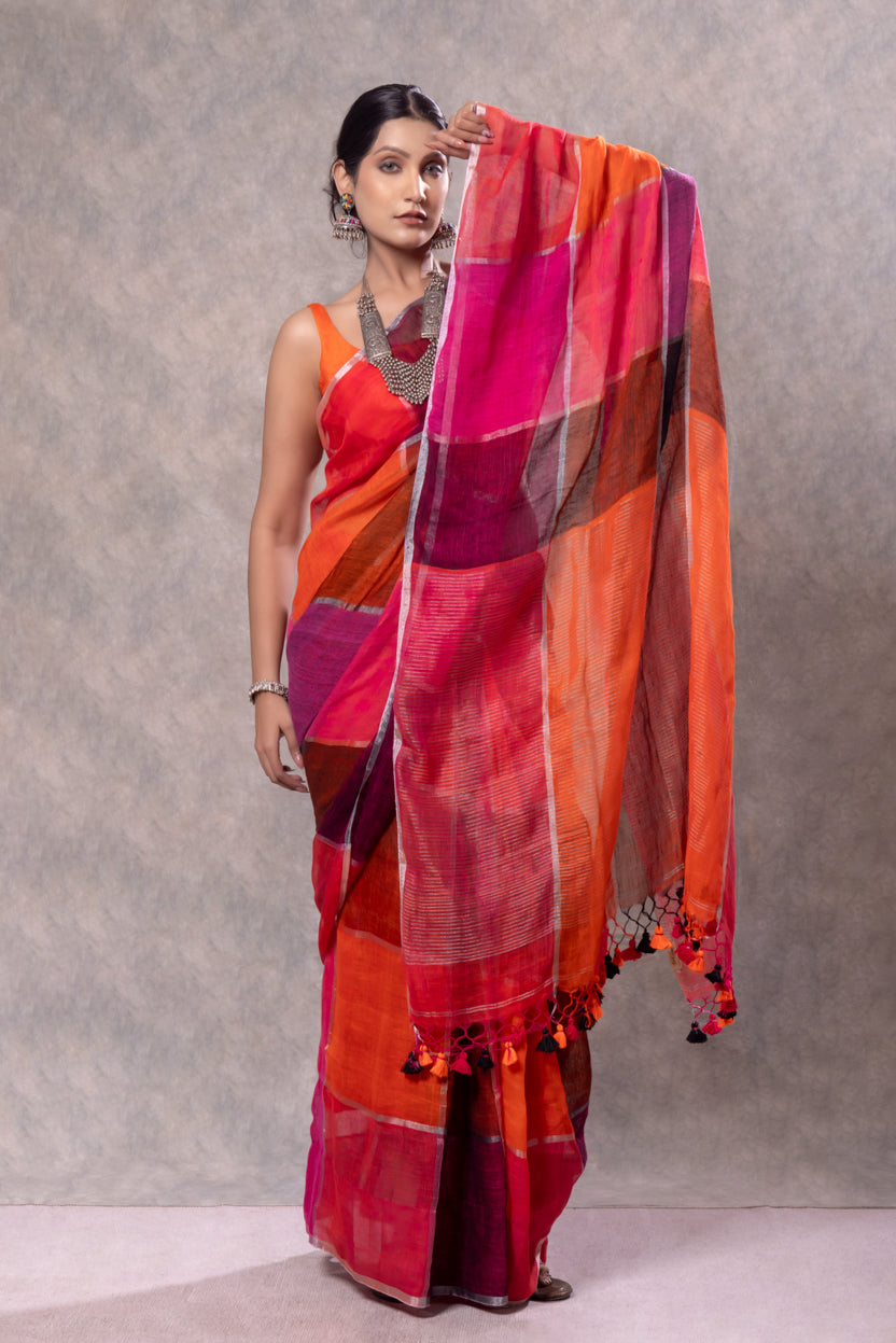 Woman holding a colorful saree against a plain background