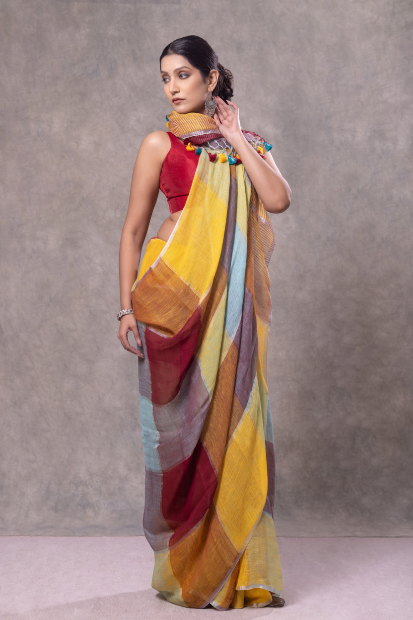 Woman wearing a colorful saree against a gray background