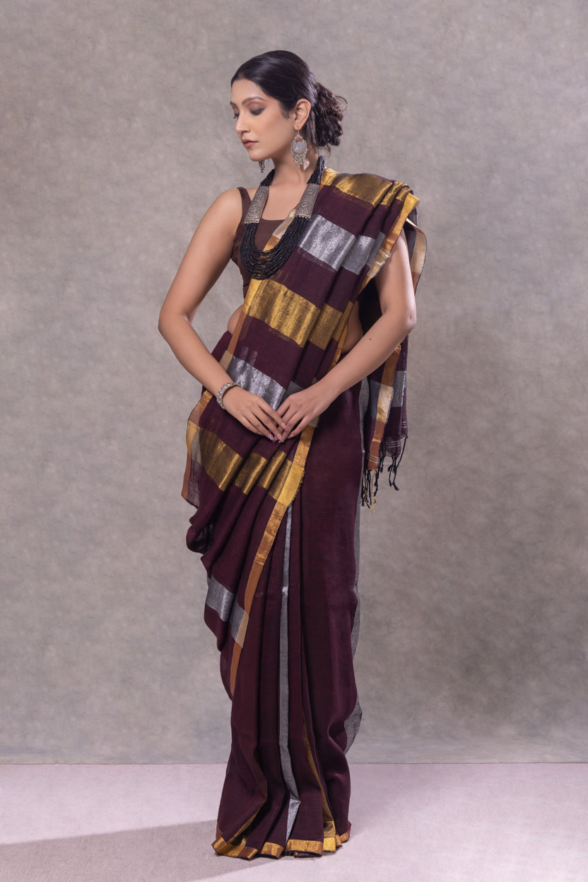 Woman wearing a traditional saree with a gradient of colors against a plain background