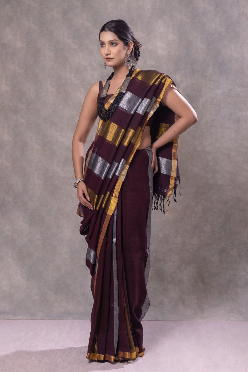Woman wearing a traditional saree with a patterned shawl against a gray background