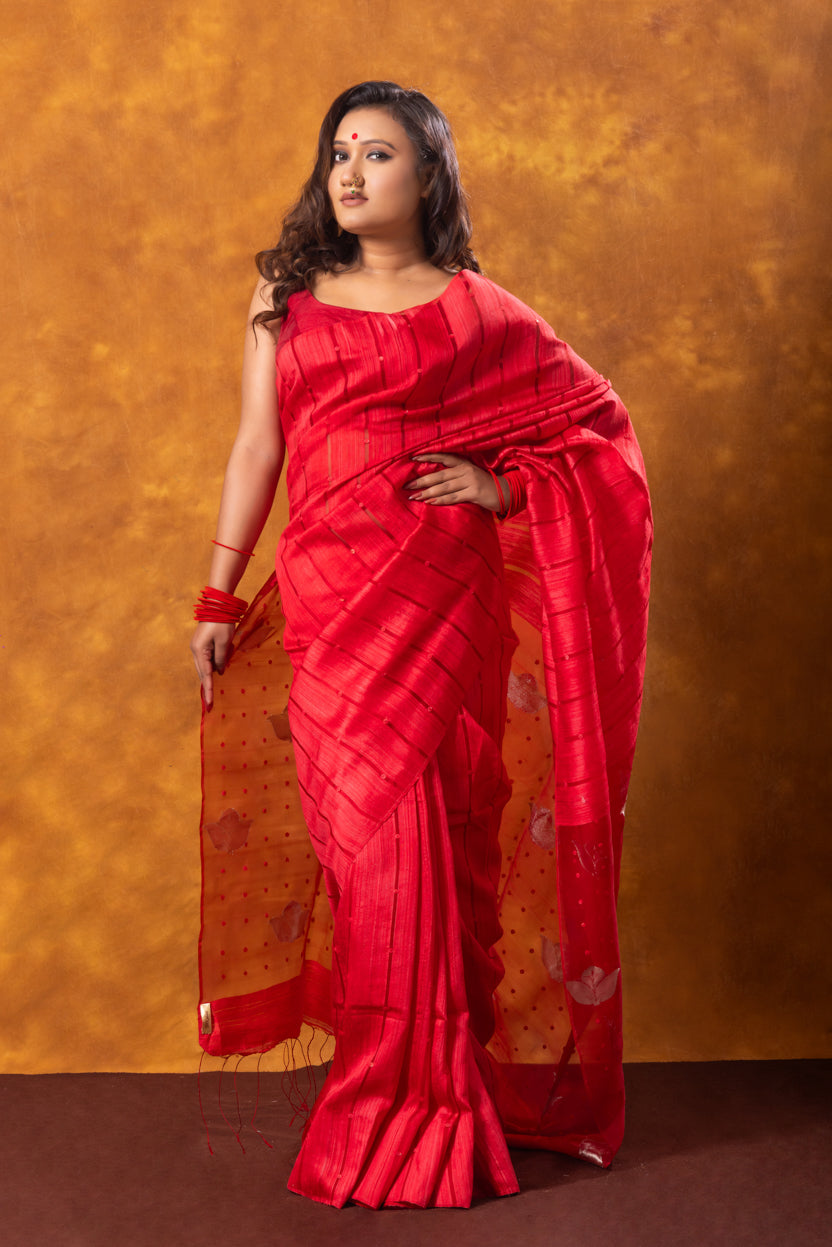Woman wearing a red saree against an orange background