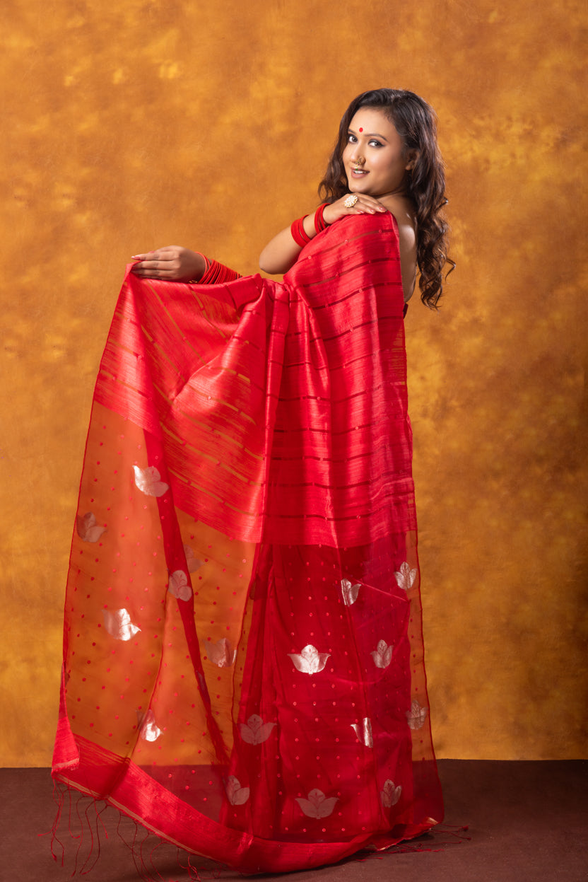 Woman wearing a red saree with a gold background