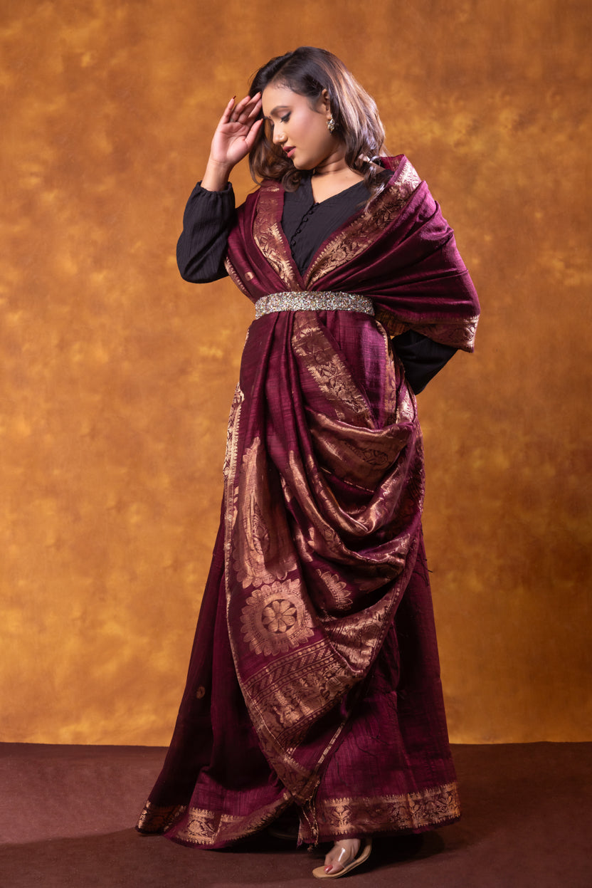 Woman wearing a purple and gold traditional outfit against an orange background