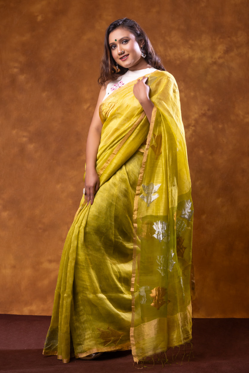 Woman wearing a yellow saree with a white blouse against a brown background
