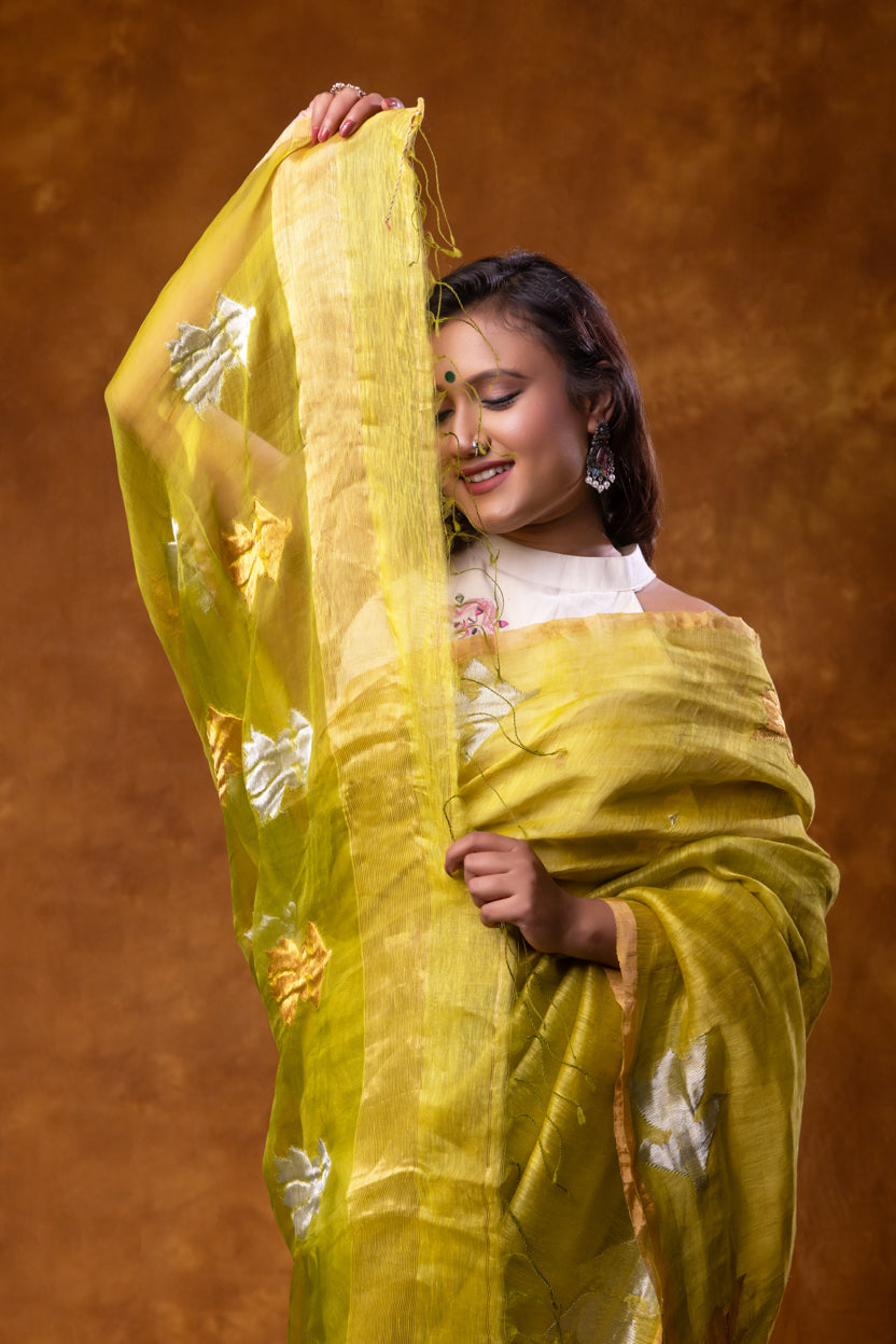 Woman wearing a yellow saree with a brown background
