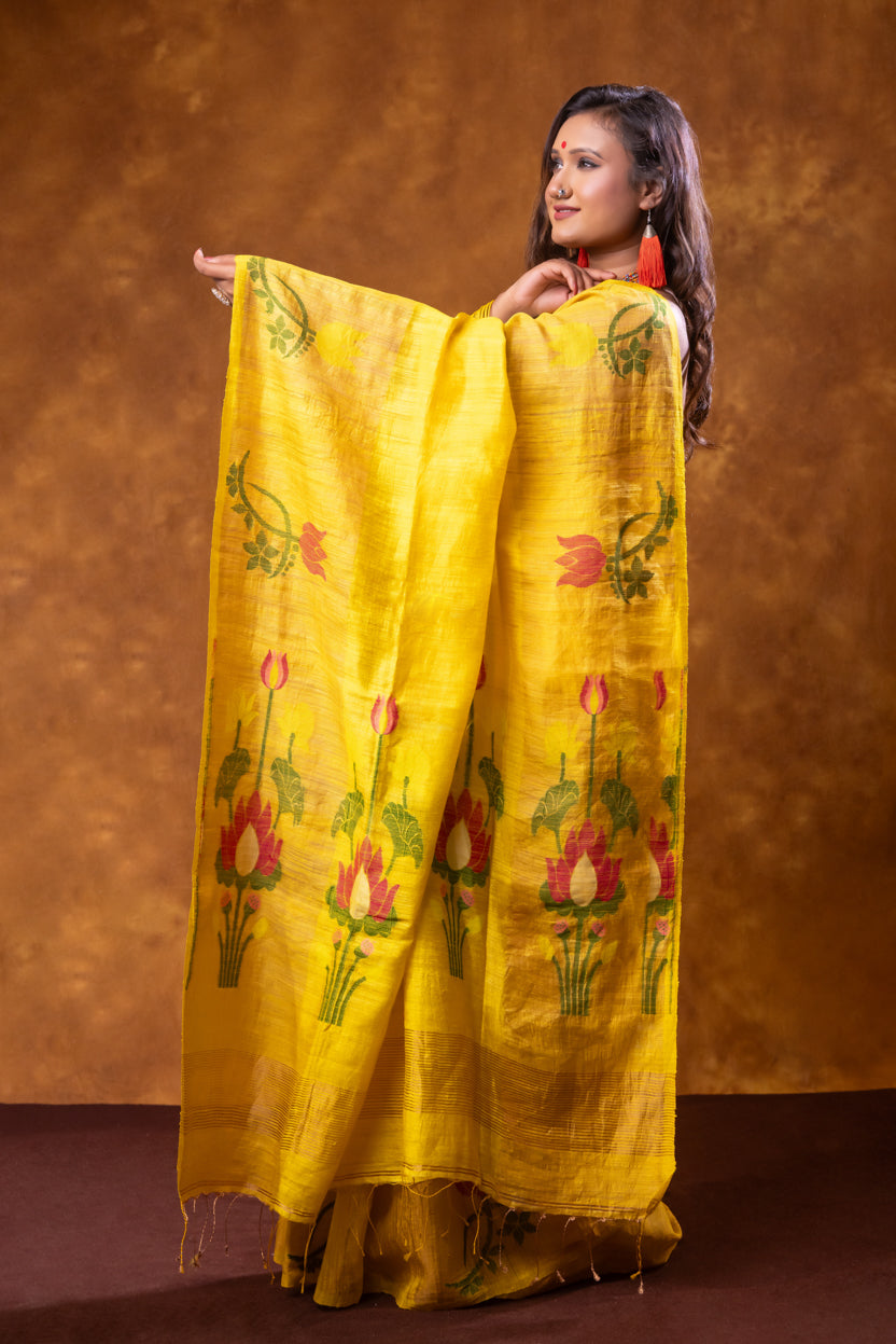 Woman holding a yellow floral saree against a brown background