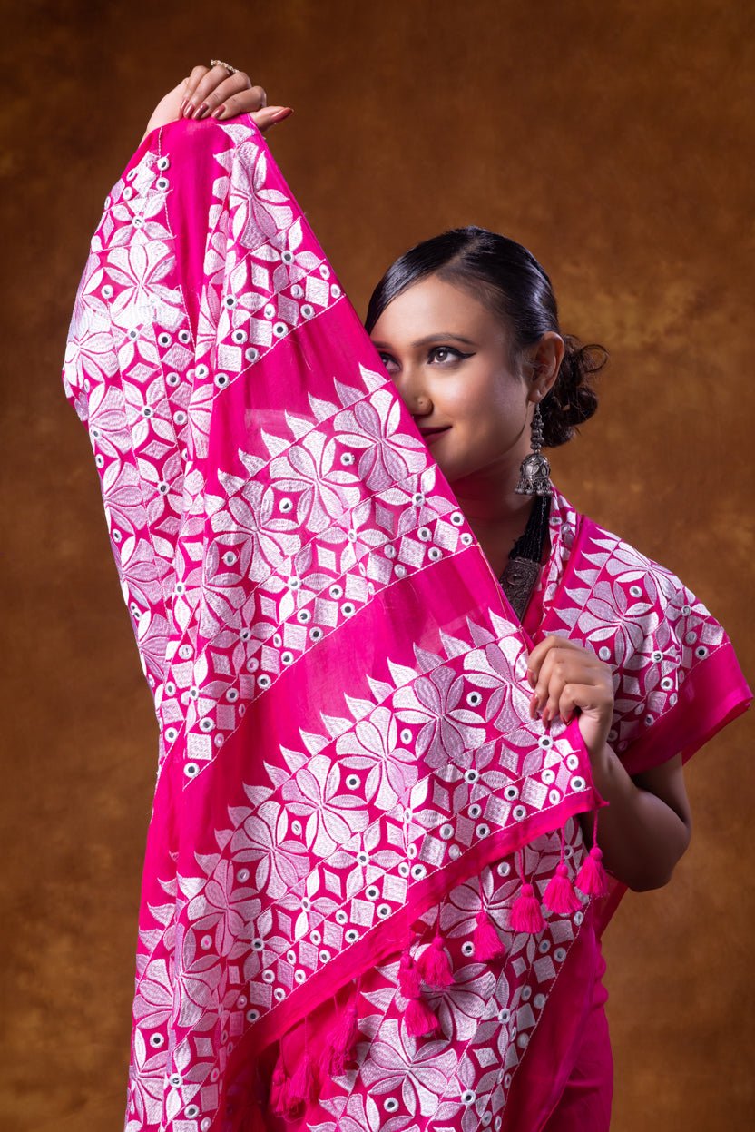 Woman holding a pink and white patterned scarf against a brown background