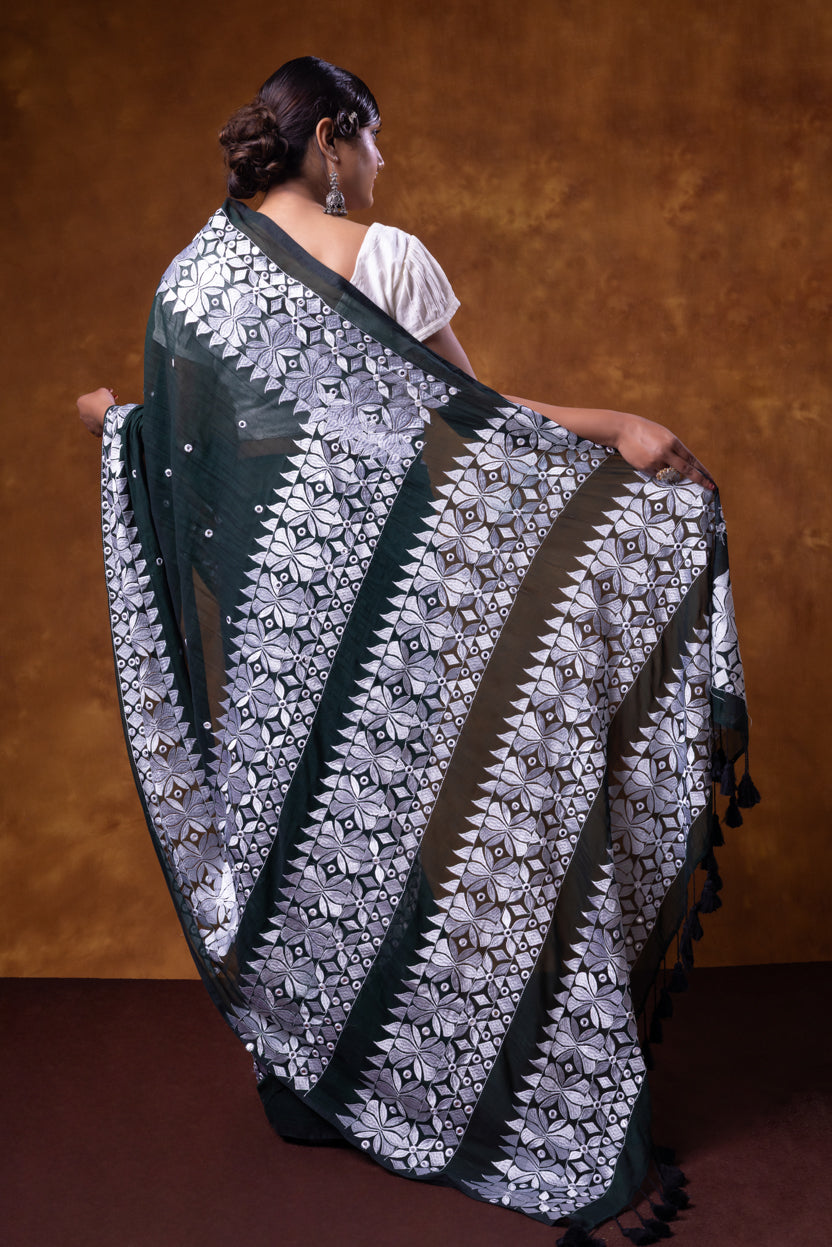 Woman wearing a black and white patterned shawl against a brown background