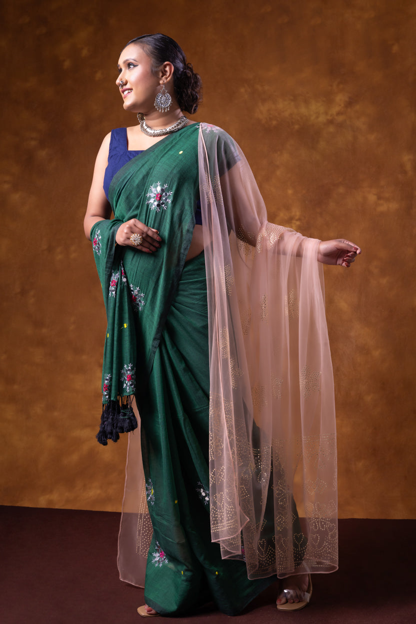Woman wearing a green saree with a brown background