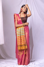 Woman wearing a pink saree with a striped border against a white background