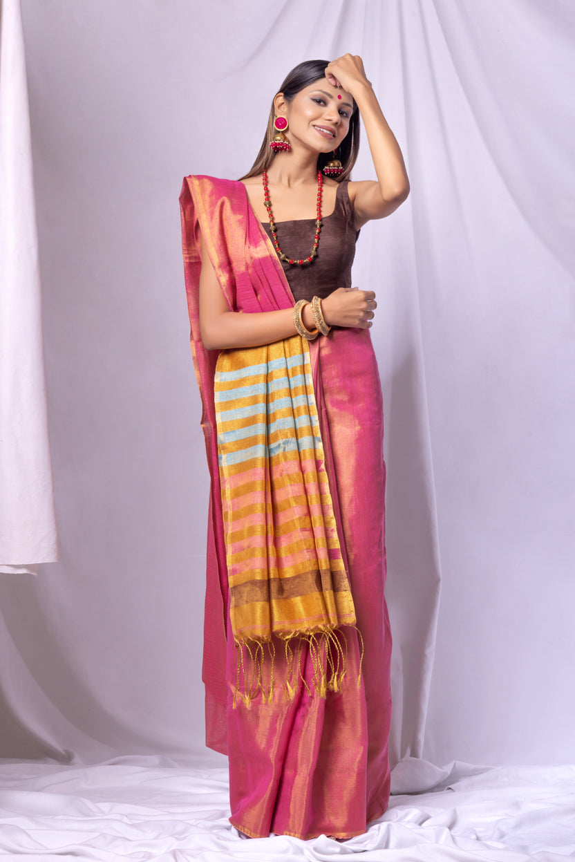 Woman wearing a pink saree with a striped border against a white background