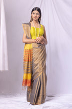 Woman wearing a traditional saree with a yellow blouse against a white background