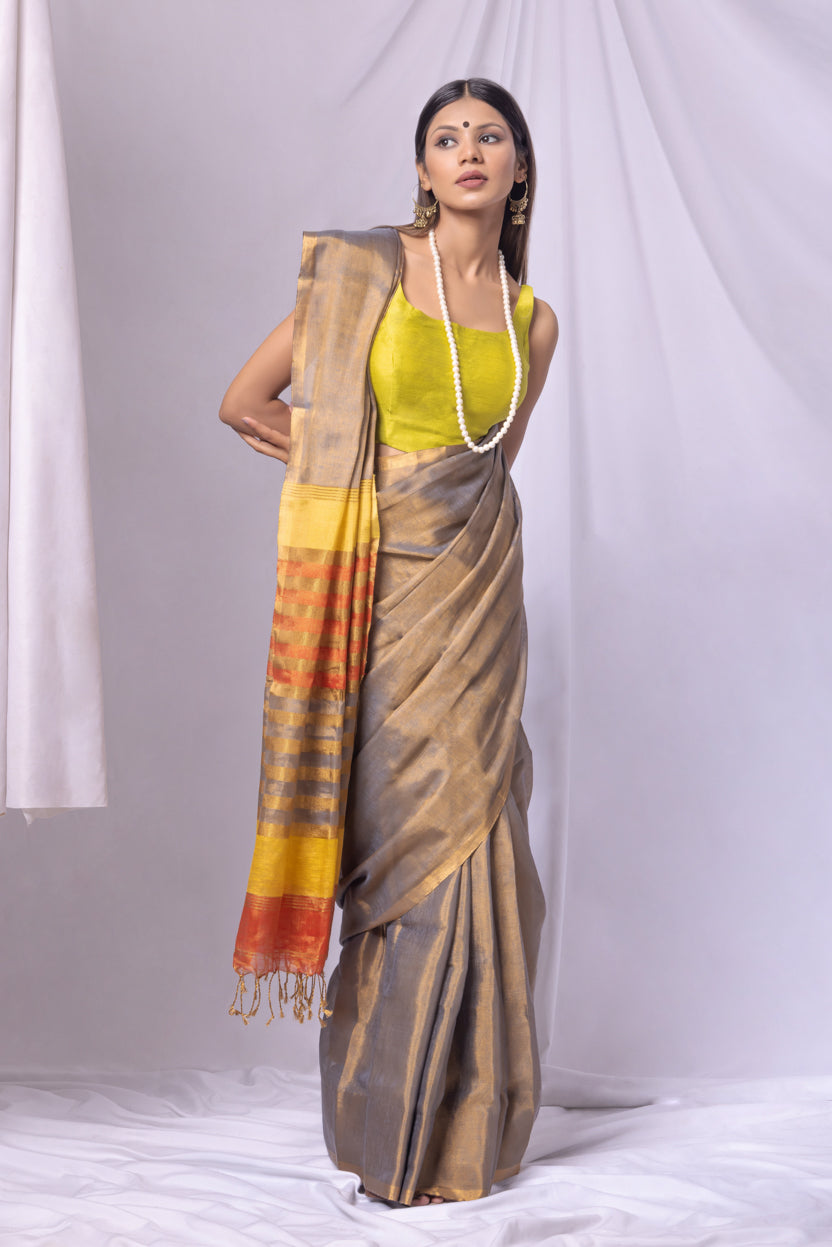 Woman wearing a traditional saree with a colorful border against a white background