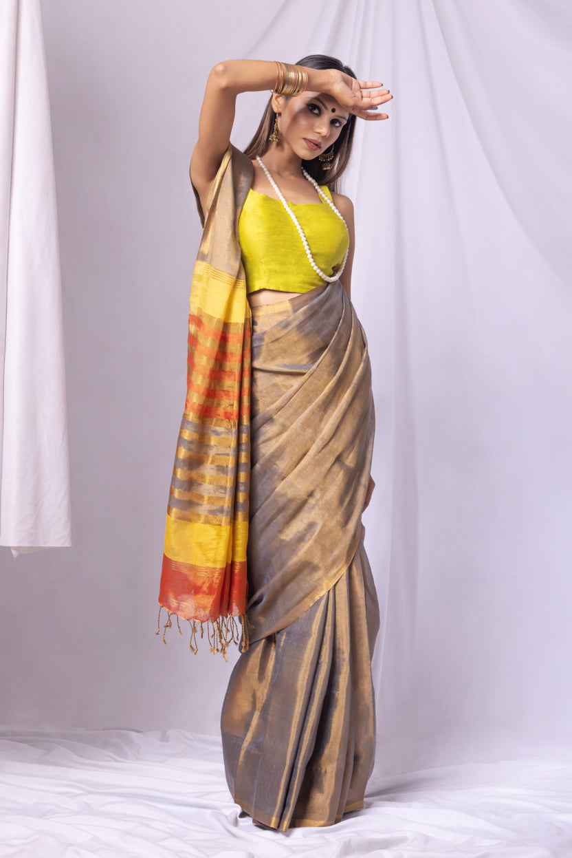 Woman wearing a traditional saree with a colorful border against a white background