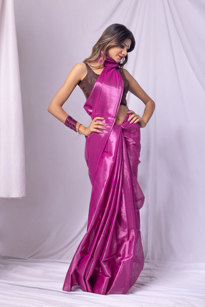 Woman wearing a vibrant pink saree with a white background