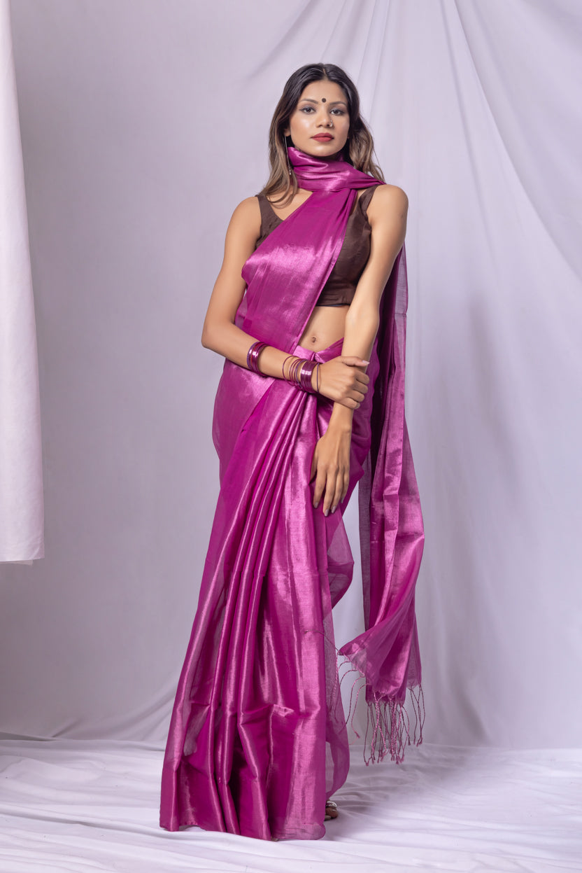 Woman wearing a vibrant pink saree with a white background