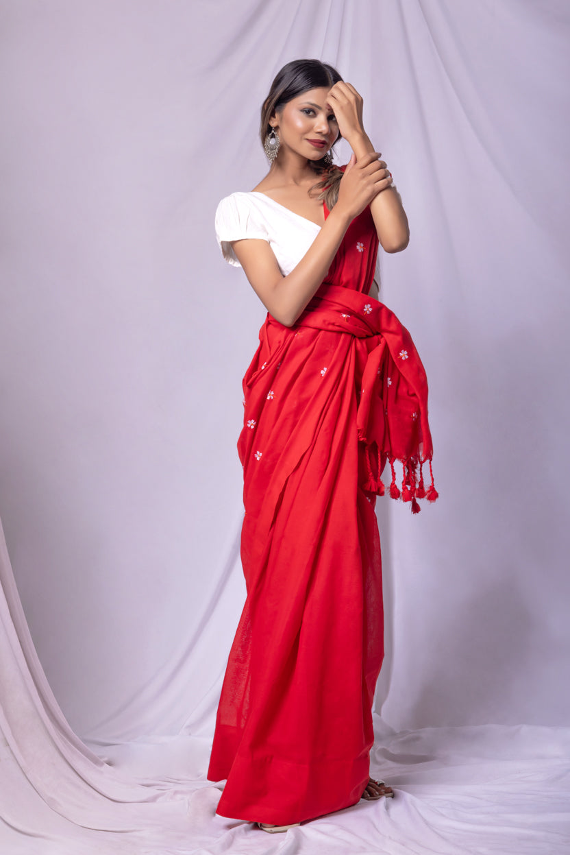 Woman wearing a red saree with white blouse against a white background
