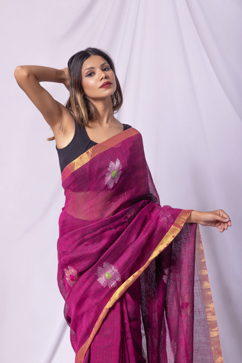 Woman wearing a purple saree with floral patterns on a white background