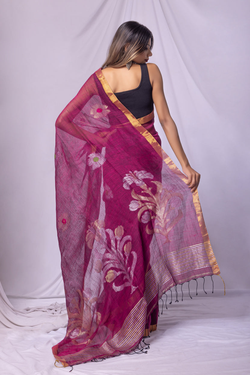 Woman wearing a pink saree with floral patterns on a white background