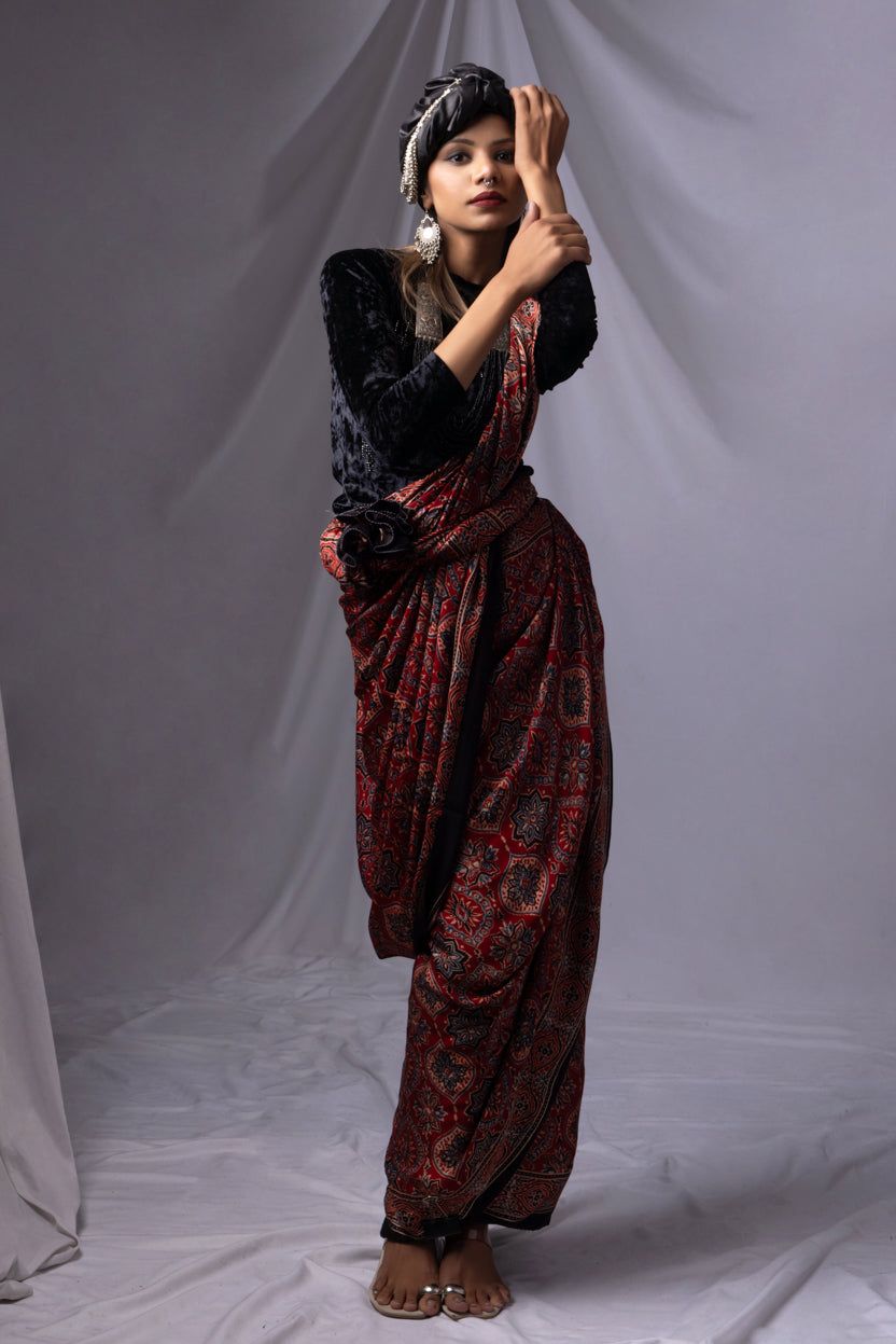 Woman in a patterned dress posing against a plain background