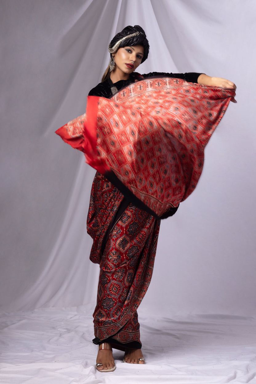 Woman wearing a red and black patterned saree with a white background