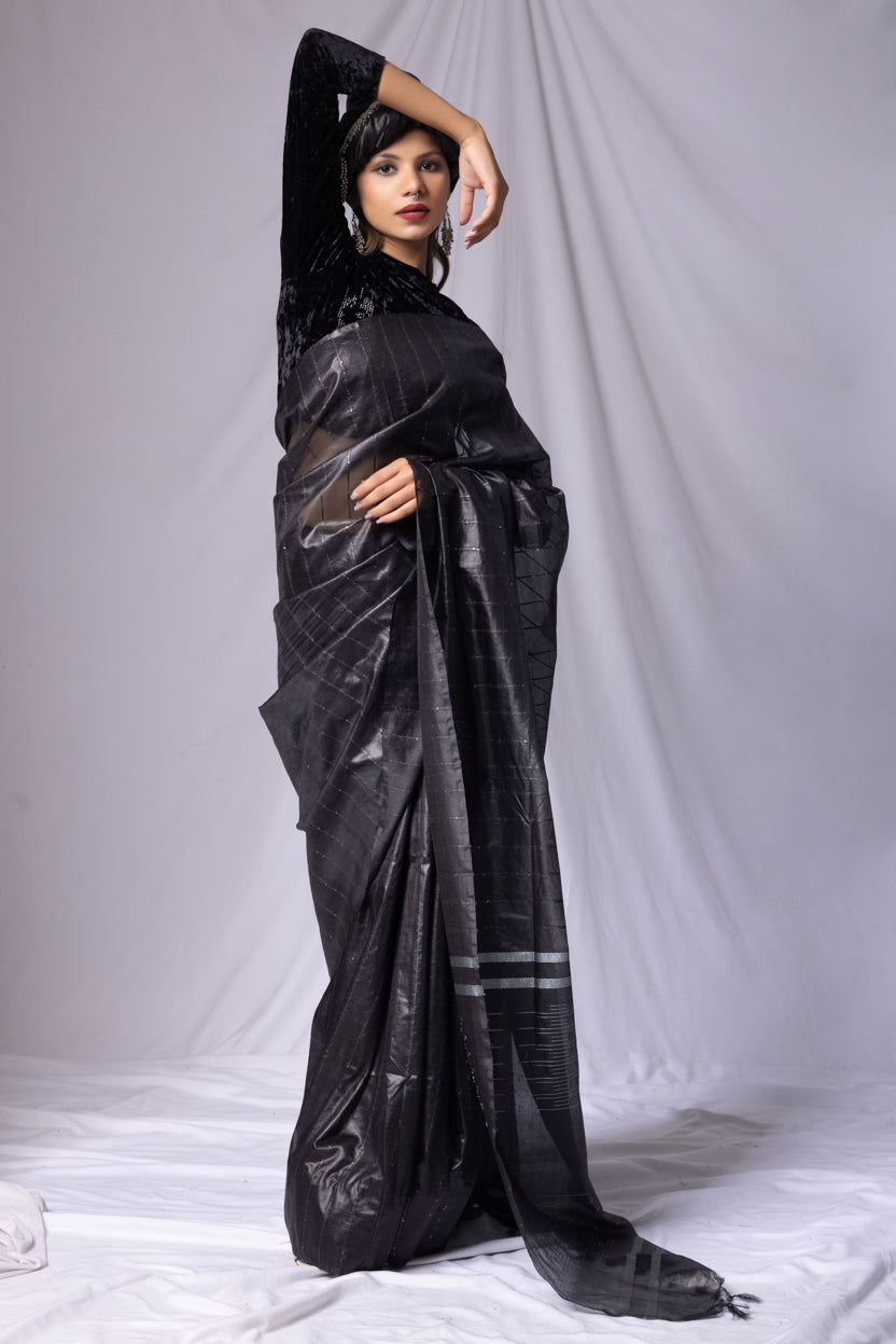 Woman wearing a black saree with a white background