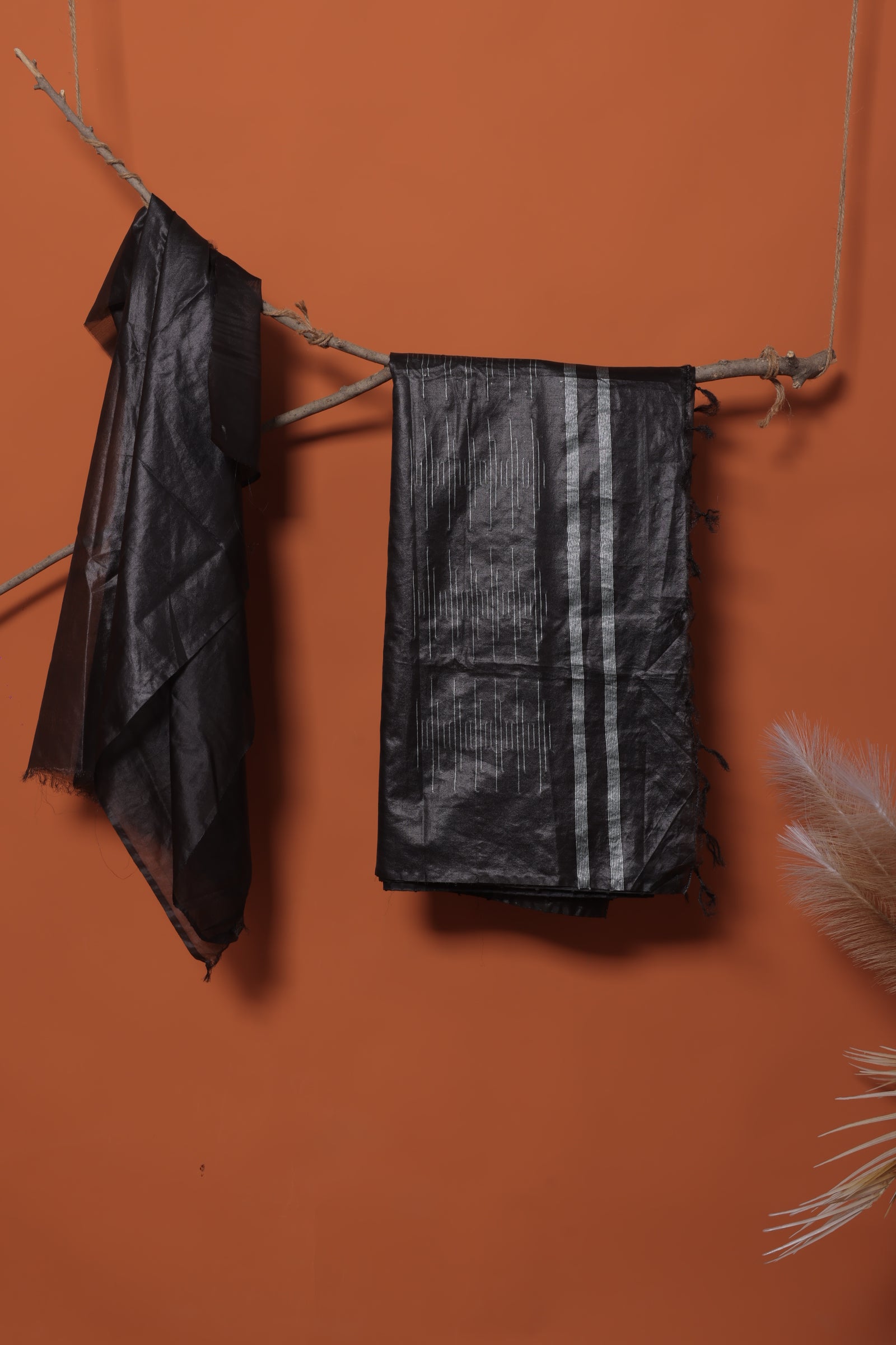 Woman wearing a black outfit with a large black and gray scarf against a white background